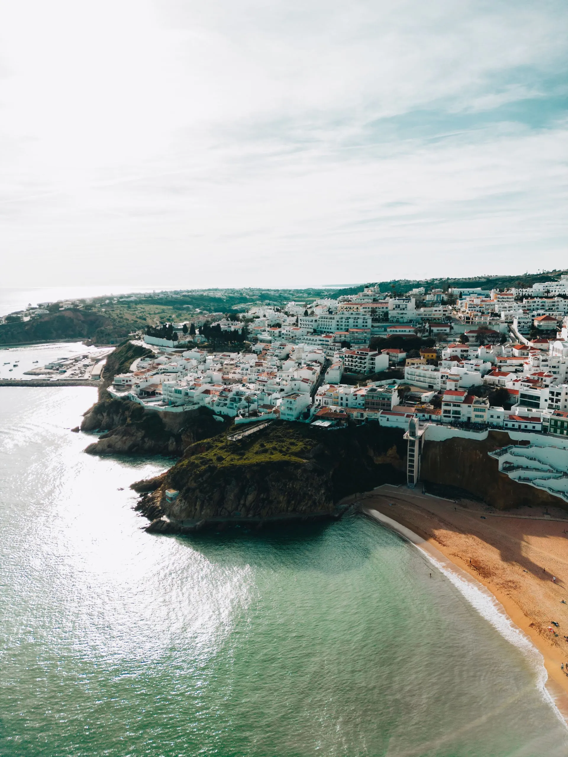 Whitewashed seaside town on the Algarve coast under a clear blue sky